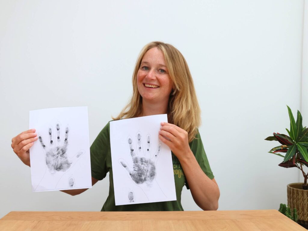 vrouw houdt handafdrukken omhoog