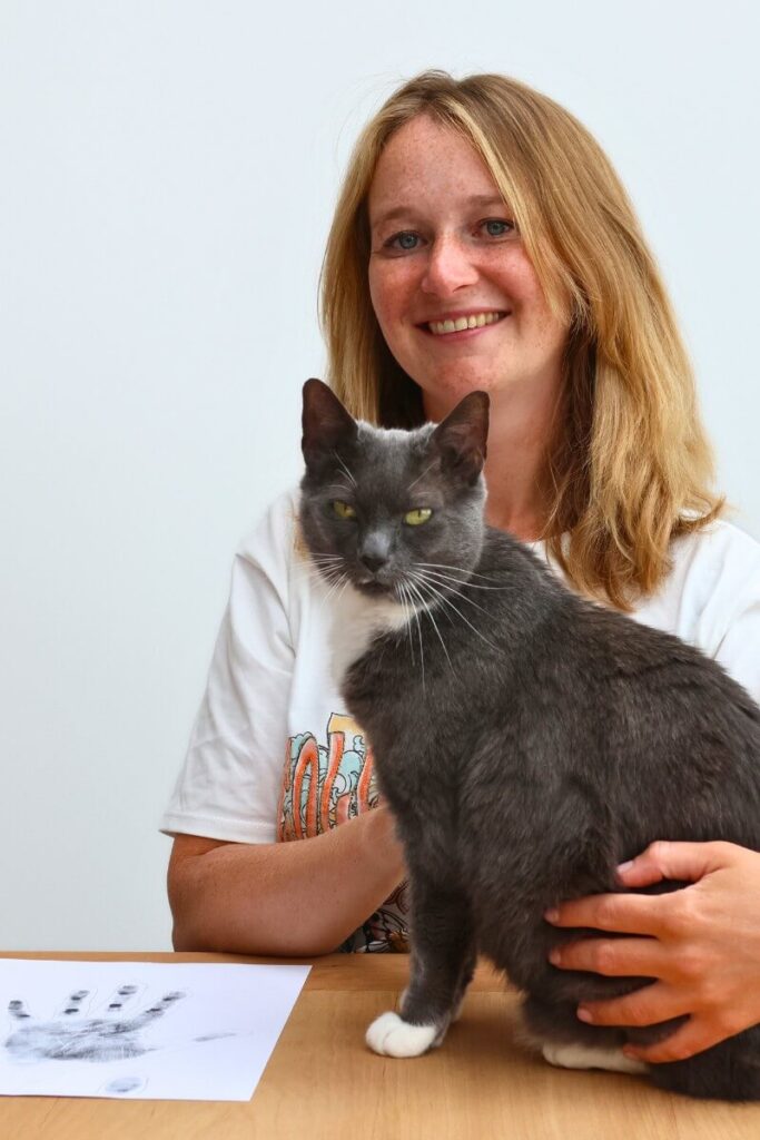 vrouw met kat op tafel en twee handafdrukken